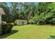 Spacious backyard with a storage shed, lush lawn, and mature trees at 15 Miners Pt Se, Acworth, GA 30102