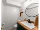 Modern half bath featuring wood countertop and a round mirror at 15 Miners Pt Se, Acworth, GA 30102