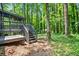 A multi-tiered backyard with access to a screened porch, deck, and stair access to a wooded backyard at 2136 N Landing Way, Marietta, GA 30066