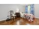 Cozy bedroom featuring hardwood flooring, bright window, and a chair with striped pillows at 2136 N Landing Way, Marietta, GA 30066