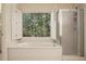 Bathroom features large tub beneath a window, as well as a glass-enclosed shower at 2695 Moon Cabin Dr, Powder Springs, GA 30127
