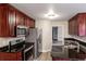 Kitchen featuring stainless steel appliances, dark granite counters and warm wood cabinetry at 2082 Blackberry Ln, Auburn, GA 30011