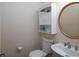 Cozy half bath with toilet, rounded sink, and small storage cabinet above the commode at 4601 Gann Sw Xing, Smyrna, GA 30082