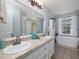 Bathroom featuring double sinks, soaking tub under window, neutral tile, and modern lighting at 4601 Gann Sw Xing, Smyrna, GA 30082