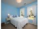 Bright blue bedroom features double windows with decorative curtains, side table, and overhead lighting at 4601 Gann Sw Xing, Smyrna, GA 30082