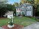 Two-story home with gray siding, white trim, a well-maintained lawn, and attractive landscaping at 4601 Gann Sw Xing, Smyrna, GA 30082