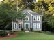 Charming two-story home featuring gray siding, white trim, manicured lawn, and lush landscaping at 4601 Gann Sw Xing, Smyrna, GA 30082