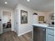 Open kitchen design with stainless steel dishwasher, white countertop, and connection to dining and living areas at 4601 Gann Sw Xing, Smyrna, GA 30082
