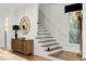Modern staircase with glass railing, complemented by a stylish console table and decorative mirror at 538 Sarabrook Pl, Sandy Springs, GA 30342