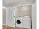 Convenient laundry room with washer, dryer, wire shelf, and white doors at 70 Prince Edward Way, Covington, GA 30016