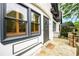 Close up of the entryway with charming wood shutters, stone porch, and a rustic black door at 1448 N Highland Ne Ave, Atlanta, GA 30306
