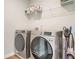 Well-equipped laundry room with modern washer and dryer, and convenient overhead storage shelf at 2820 Aralynn Way, Atlanta, GA 30337