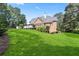 Expansive backyard with lush green lawn and a brick home with a white deck at 4759 Highland Point Dr, Auburn, GA 30011