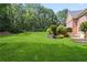 Expansive backyard with lush green lawn and manicured landscaping surrounding the brick home at 4759 Highland Point Dr, Auburn, GA 30011