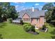 Aerial view of a large backyard with a lush green lawn and a brick home with a deck at 4759 Highland Point Dr, Auburn, GA 30011