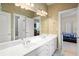 Bathroom featuring double sink vanity, large mirror, and views to rooms down the hall at 4759 Highland Point Dr, Auburn, GA 30011
