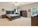Spacious bedroom with dark wood furniture, ceiling fan, and bright natural light at 4759 Highland Point Dr, Auburn, GA 30011