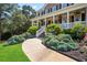 Landscaped walkway leading to a charming brick home with a welcoming porch at 4759 Highland Point Dr, Auburn, GA 30011