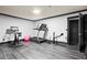 Brightly lit home gym with wood floors and featuring a treadmill, stationary bike, and free weights at 4759 Highland Point Dr, Auburn, GA 30011