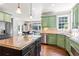 Open kitchen with island, breakfast bar, stainless steel appliances, and green cabinetry at 4759 Highland Point Dr, Auburn, GA 30011