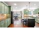 Gourmet kitchen with island, hardwood floors, stainless steel appliances, and green cabinetry at 4759 Highland Point Dr, Auburn, GA 30011
