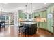 Bright kitchen featuring green cabinets, a center island with seating, and hardwood floors at 4759 Highland Point Dr, Auburn, GA 30011