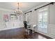 Elegant office with stylish chandelier, detailed trim, and natural light from a window, creating an inspiring workspace at 4759 Highland Point Dr, Auburn, GA 30011