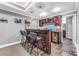 Basement bar area featuring a dark wood bar, stools, backsplash, and slate flooring at 4771 Moon Chase Dr, Buford, GA 30519