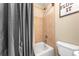 Cozy bathroom with shower-tub combo featuring neutral-toned tile and dark gray shower curtain at 4771 Moon Chase Dr, Buford, GA 30519