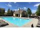Community pool with clear blue water, ample lounge chairs, and a charming pool house at 4771 Moon Chase Dr, Buford, GA 30519