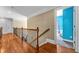 View of the upstairs hallway with hardwood floors and iron railing at 4771 Moon Chase Dr, Buford, GA 30519