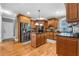 Well-lit kitchen featuring stainless steel appliances, a center island, and warm wood cabinetry at 4771 Moon Chase Dr, Buford, GA 30519