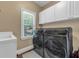 Modern laundry area with front loading washer and dryer and utility sink at 4771 Moon Chase Dr, Buford, GA 30519