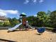 Community playground featuring a slide and a bouncy blue horse, set amongst a background of trees and blue sky at 4771 Moon Chase Dr, Buford, GA 30519
