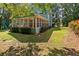 Backyard featuring a screened-in porch, lush lawn, and privacy from mature trees at 533 Coolsprings Walk, Woodstock, GA 30188