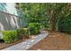 Landscaped backyard with a sidewalk, decorative shrubs, and a beautiful canopy of trees overhead at 533 Coolsprings Walk, Woodstock, GA 30188