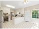 Well-lit kitchen features white cabinets, tiled floors, a stainless steel oven and backyard access at 533 Coolsprings Walk, Woodstock, GA 30188