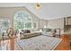 Cozy living room featuring hardwood floors, a decorative rug, large windows, and a comfortable sectional sofa at 533 Coolsprings Walk, Woodstock, GA 30188