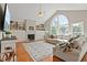 Bright living room featuring built-in shelves, a fireplace, hardwood floors, and a large window at 533 Coolsprings Walk, Woodstock, GA 30188