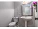 A half bathroom with a pedestal sink and decorative mirror offers a clean and simple design at 115 Winding River Dr # B, Atlanta, GA 30350