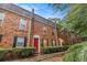 Brick townhomes boast a red front door and neatly trimmed hedges, offering charming curb appeal at 115 Winding River Dr # B, Atlanta, GA 30350