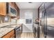 A modern kitchen features stainless steel appliances and a dedicated laundry area at 115 Winding River Dr # B, Atlanta, GA 30350