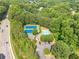 Aerial view of community tennis courts, a pool, and the surrounding lush greenery near a roadway at 3275 Cherry Oak Ln, Cumming, GA 30041