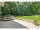 Covered back patio with seating overlooking a large grassy yard bordered by mature trees at 3275 Cherry Oak Ln, Cumming, GA 30041