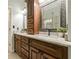 Bathroom vanity with double sinks, granite countertop, decorative mirror, and wood cabinets at 3275 Cherry Oak Ln, Cumming, GA 30041