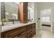Bathroom vanity with double sinks, granite countertop, decorative mirror, and view to main bedroom at 3275 Cherry Oak Ln, Cumming, GA 30041