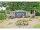 Stone community entrance sign with beautiful flower beds, offering a warm welcome to Northern Oaks at 3275 Cherry Oak Ln, Cumming, GA 30041