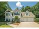 Traditional two-story home featuring a two-car garage and manicured front lawn at 3275 Cherry Oak Ln, Cumming, GA 30041