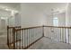 Bright hallway with a decorative railing, carpeted floor, and modern lighting at 3275 Cherry Oak Ln, Cumming, GA 30041