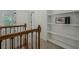Upstairs hallway featuring built in shelving, wood and metal railing, and carpet flooring at 3275 Cherry Oak Ln, Cumming, GA 30041